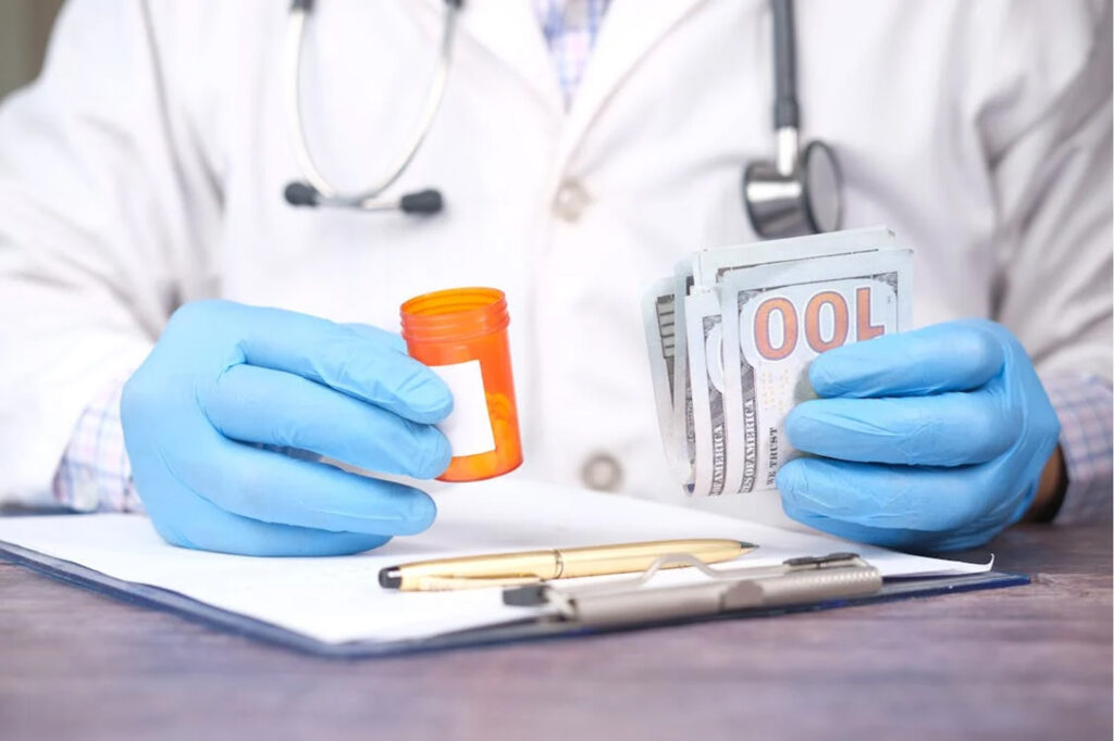 Alt tag: Doctor holding prescription bottle and money, emphasizing financial accuracy in medical claim denial management.  | medical claim denial management