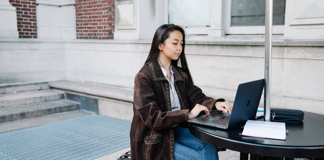 Woman using laptop outdoors, representing medical billing software for beginners. | medical billing software for beginners