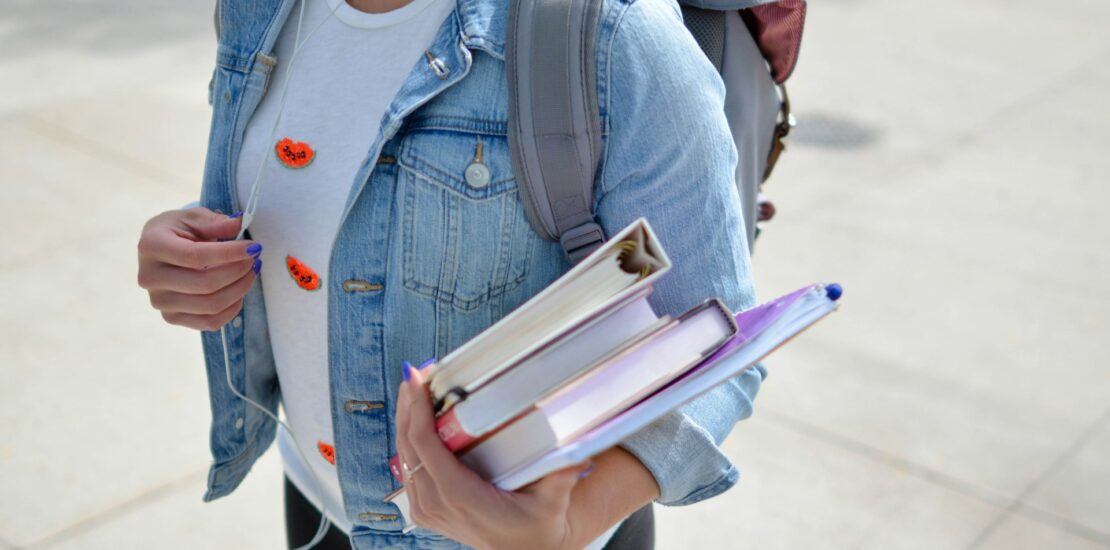 Student holding books and wearing a backpack, symbolizing medical billing education requirements. | medical billing educational requirements