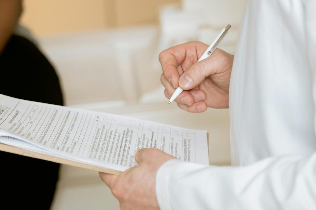 Man in a white jacket holding a pen and paper in his hand representing medical billing terminology | medical billing terminology