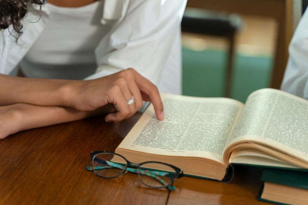 A Woman’s hand pointing at a medical billing terminology dictionary. | medical billing terminology